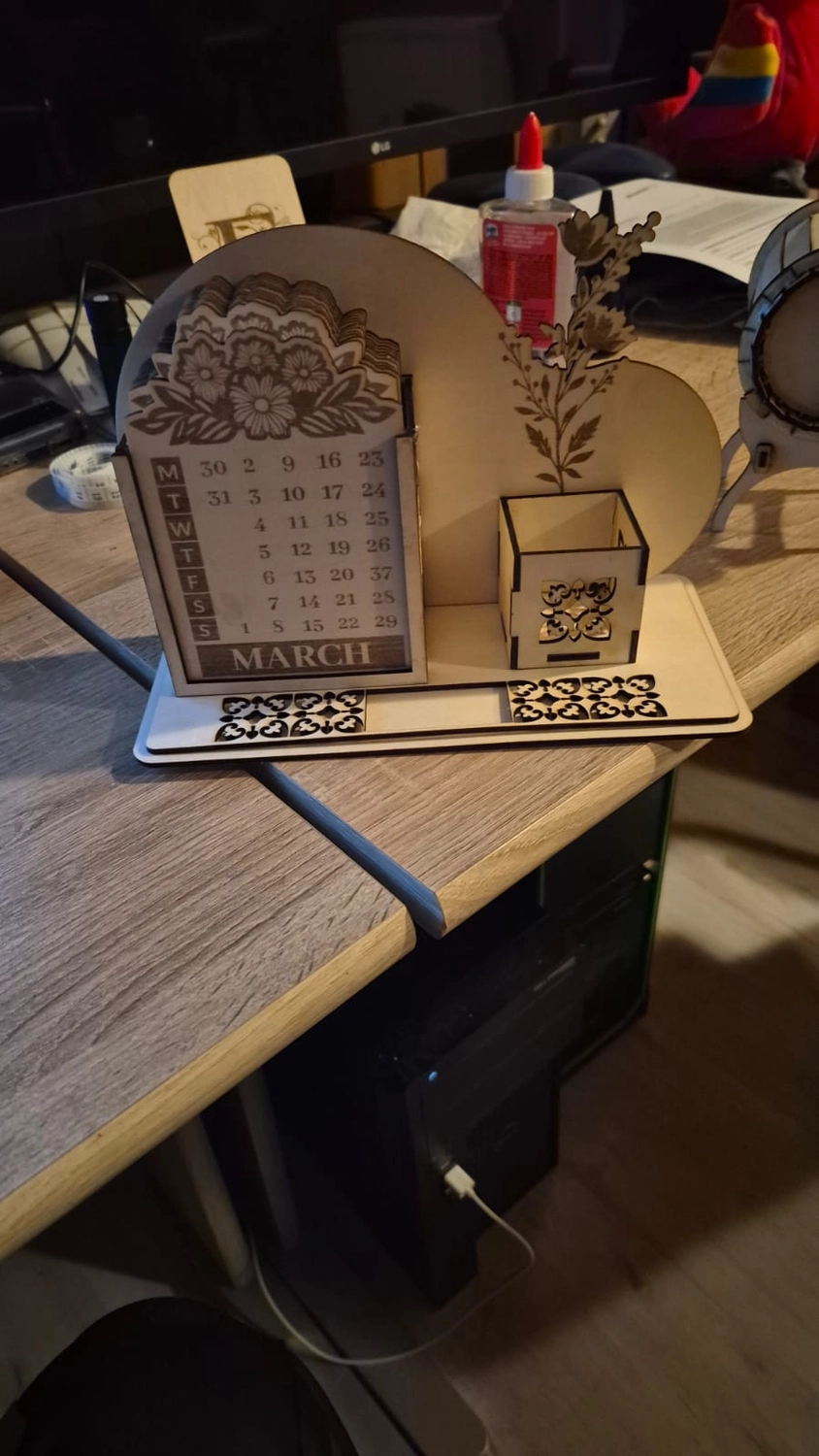 Dach,Wand und Holzkonstruktion - Handgefertigte Holzkunst - Ein dekorativer Schreibtischorganizer aus Holz mit lasergeschnittenem Kalender, einem kleinen Stifthalter und floralen Gravuren.