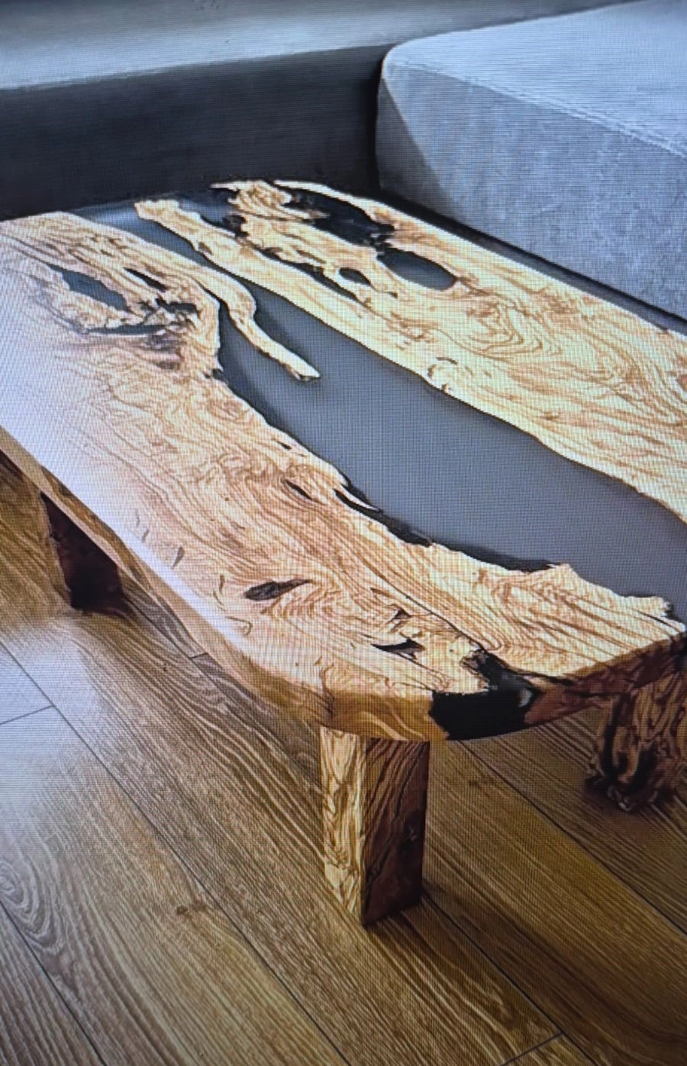 Dach,Wand und Holzkonstruktion - Handgefertigte Holzkunst - Ein rustikaler, rechteckiger Couchtisch aus dicken Holzplatten, die mit dunklem, rauchig-transparentem Harz verbunden sind.