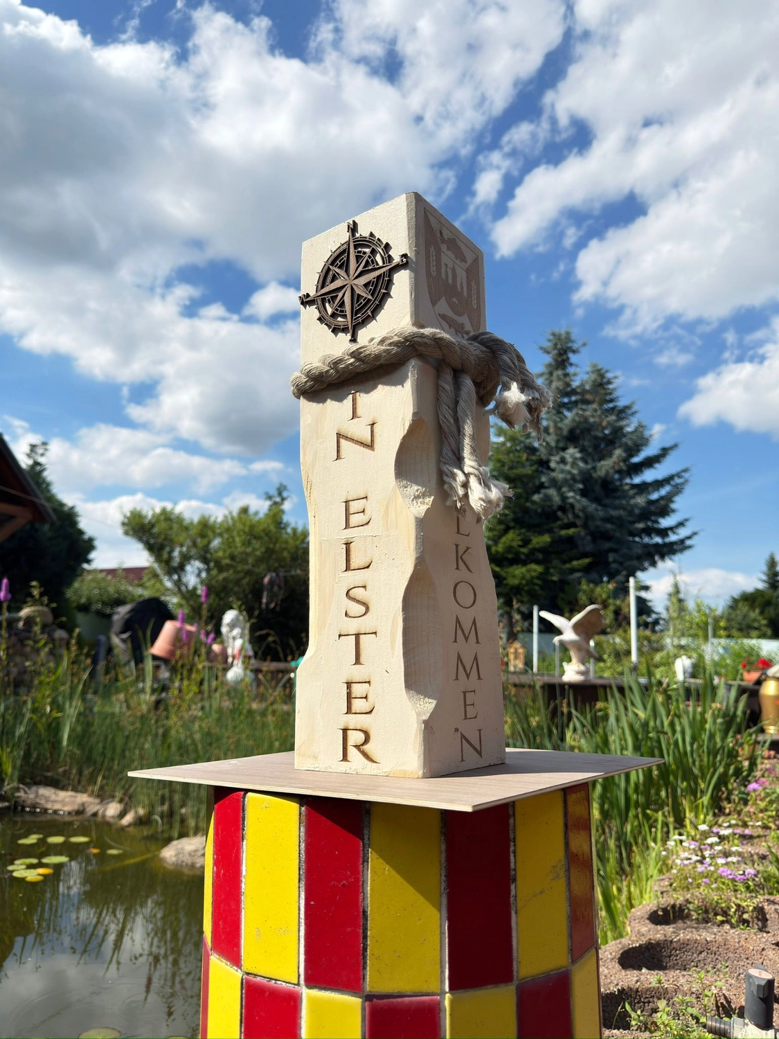 Dach,Wand und Holzkonstruktion - Handgefertigte Holzkunst - Eine Lasergravurmaschine mit 40-Watt-Etikett bearbeitet eine weiße Keramiktasse mit einem Rotationsaufsatz.
