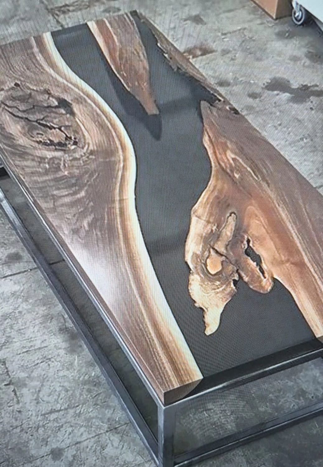 Dach,Wand und Holzkonstruktion - Handgefertigte Holzkunst - Nahaufnahme eines Tisches aus Massivholz mit einem dunkelgrauen Epoxidharz-„Fluss“-Design.