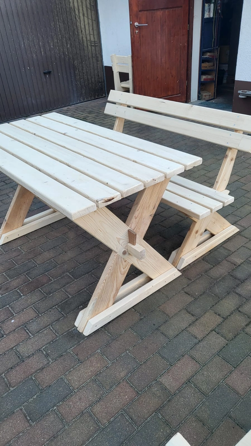 Dach,Wand und Holzkonstruktion - Handgefertigte Holzkunst - Ein helles Picknick-Set aus Holz mit Tisch und integrierter Bank mit Rückenlehne.