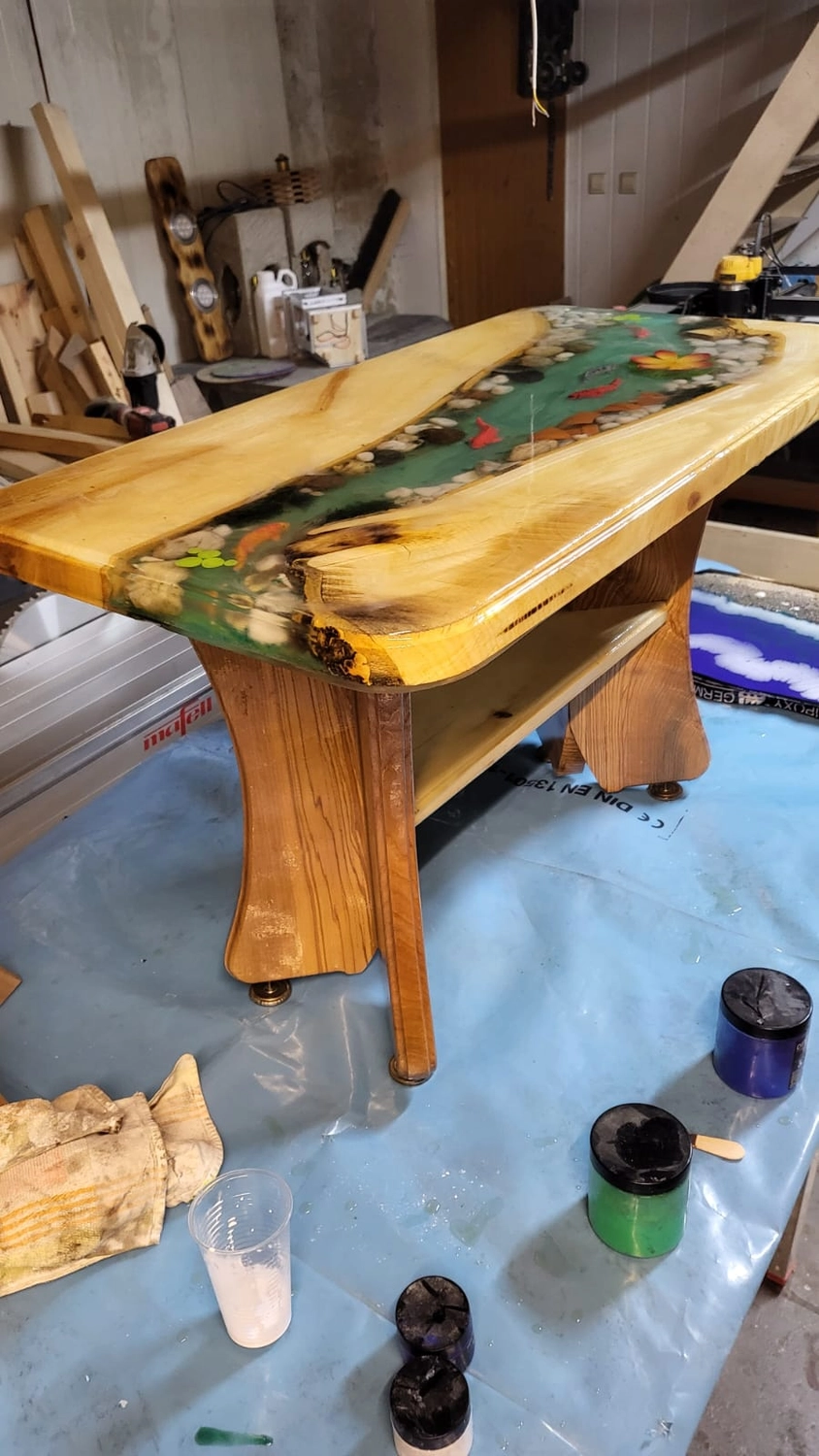 Dach,Wand und Holzkonstruktion - Handgefertigte Holzkunst - Ein Couchtisch aus Massivholz mit einer durchscheinenden, grünen Harzeinlage in Form eines Flusses.